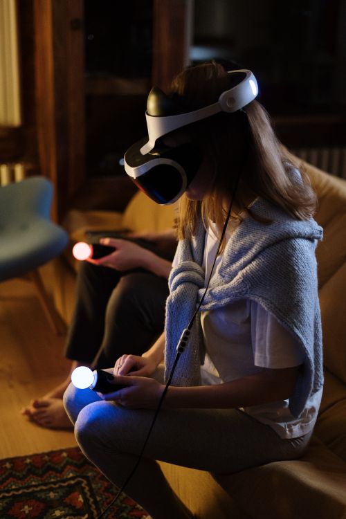 Free A couple immersed in virtual reality gaming at home with VR headsets and controllers. Stock Photo
