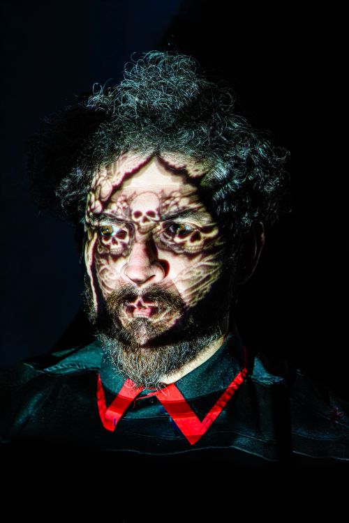 Free Portrait of a man with skull pattern shadows on his face, creating a moody and artistic effect. Stock Photo