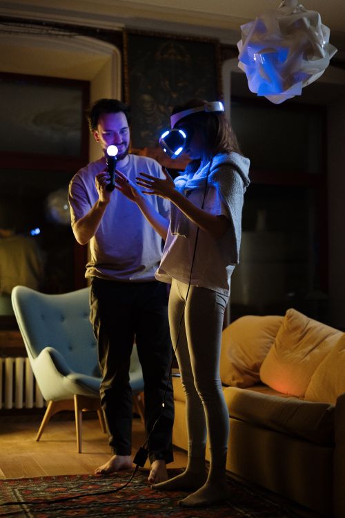 Free A couple engaged in a virtual reality gaming session in a cozy living room setting. Stock Photo