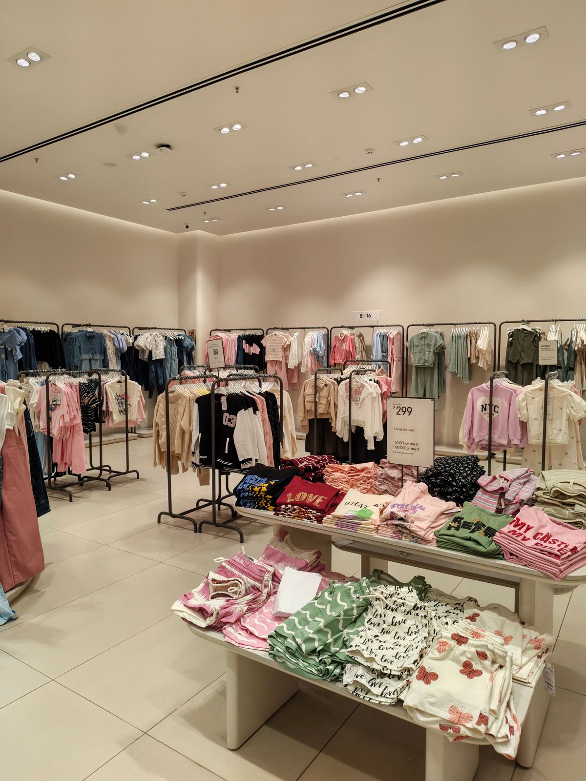 ร้านเสื้อผ้าที่จัดวางสินค้าบนราวและโต๊ะ