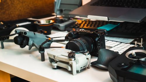 Free A professional workspace featuring a camera and drones on a desk, ideal for creative projects. Stock Photo