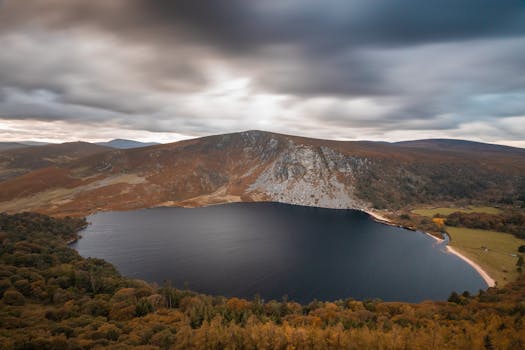 Stunning view of Lough Tay's serene waters and autumnal hills in County Wicklow, Ireland.
