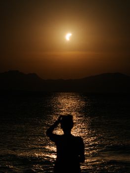A captivating silhouette against a solar eclipse over the Baleary sea.
