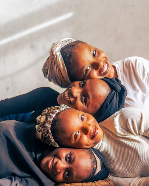 Free Vibrant portrait of four adult women smiling, showcasing joy and friendship. Perfect for lifestyle and people themes. Stock Photo