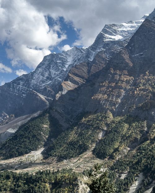 Free A breathtaking view of a snow-capped mountain range under a blue sky with scattered clouds. Stock Photo