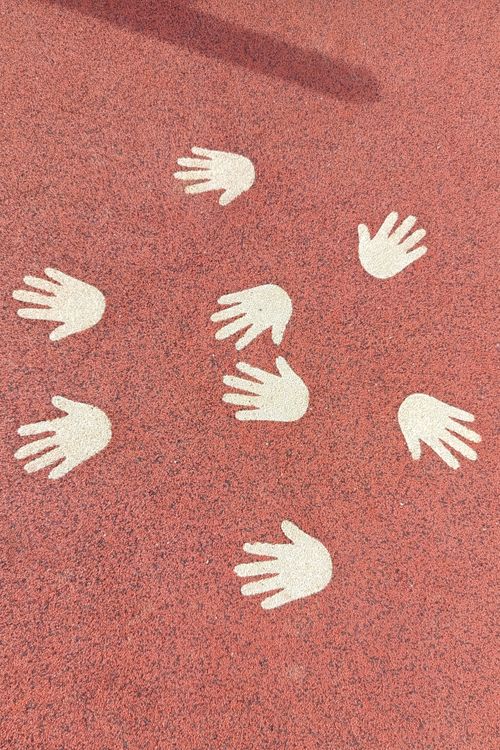 Free Playground surface featuring white handprint patterns on a red background. Stock Photo