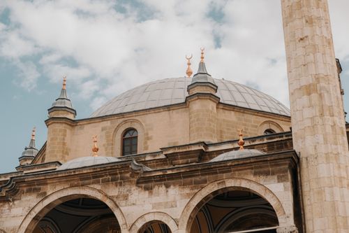 Free A stunning view of the intricate dome and minaret of a mosque in Konya, Türkiye against a blue sky. Stock Photo