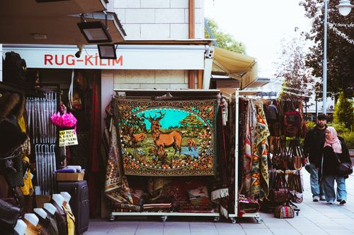 Free Outdoor market stall in Konya displaying colorful rugs and kilims. Local textiles on offer. Stock Photo