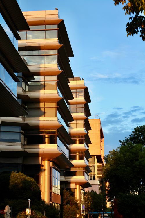Free Modern architectural building exterior during sunset with reflective glass. Stock Photo