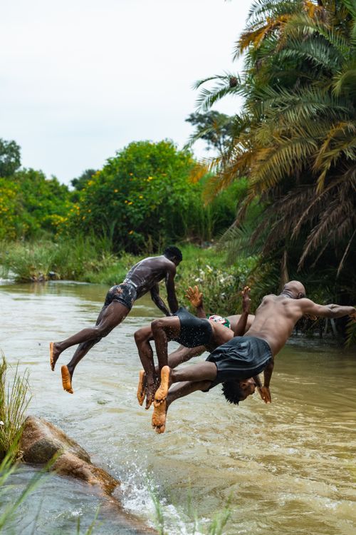 Free Group of young men enjoying a refreshing dive into a river in Jos, Nigeria. Stock Photo