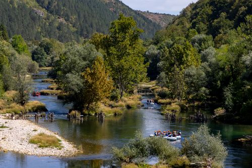 Free People rafting on the scenic Una River in Bosnia, surrounded by lush green forest. Stock Photo