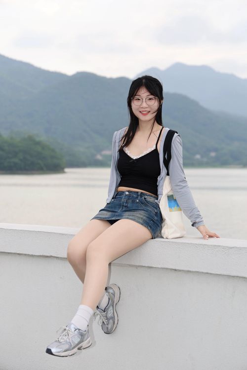 Free Young woman enjoying the view by a lake in Hefei, Anhui, China, with mountains in the background. Stock Photo