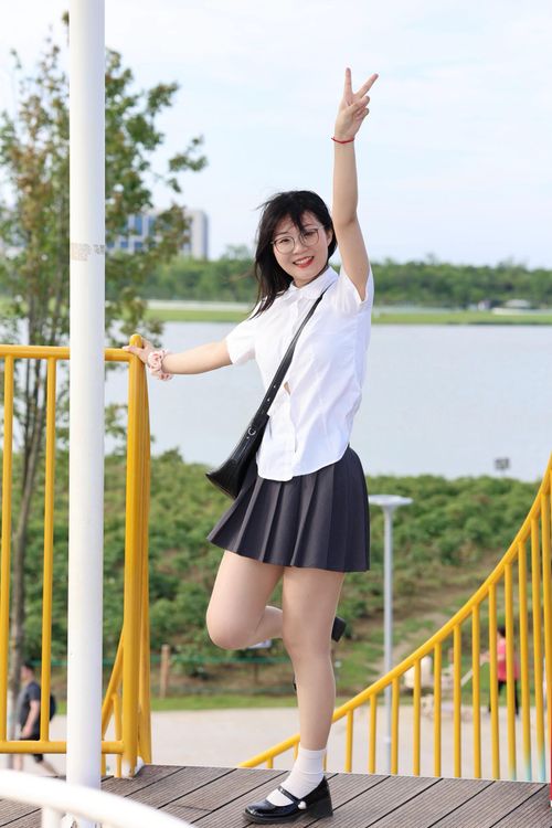 Free Cheerful young woman striking a peace sign pose on a sunny day at a park in Hefei, China. Stock Photo