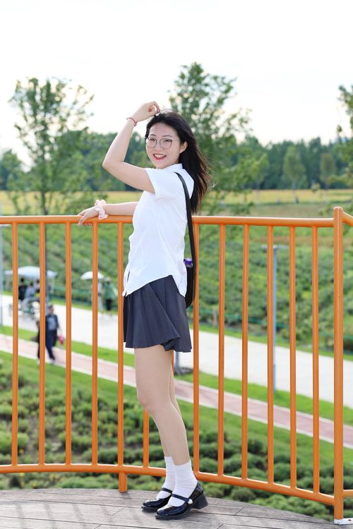 Free Smiling young woman posing casually at a park in Hefei, Anhui, China with a scenic background. Stock Photo