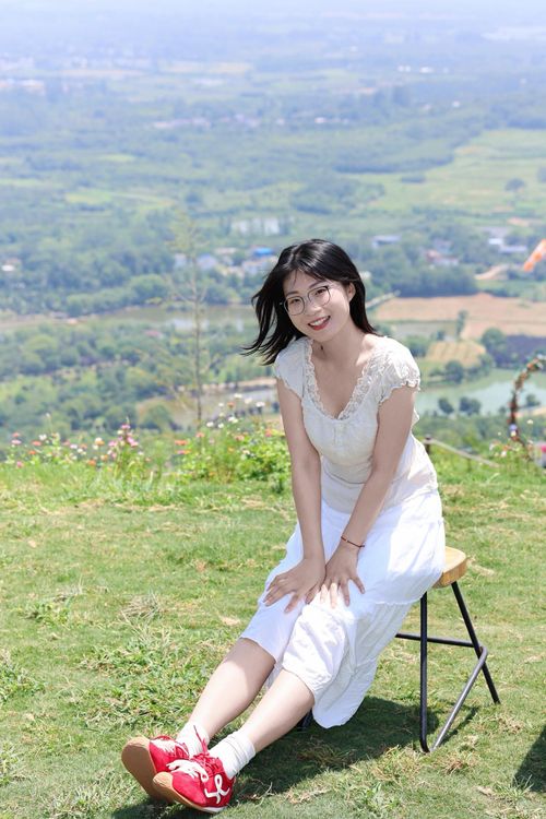 Free A smiling young woman seated outdoors with a scenic view in Hefei, Anhui, China. Stock Photo