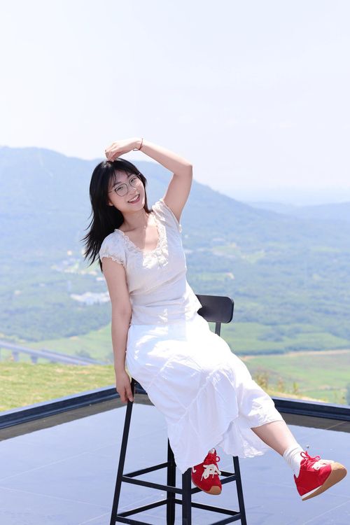 Free Young woman in a white dress enjoying a sunny day on a mountain in Hefei, China. Stock Photo