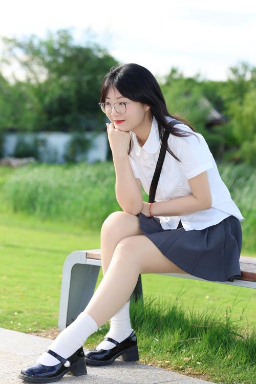 Free A thoughtful young woman sits on a park bench in Hefei, China, on a sunny day. Stock Photo