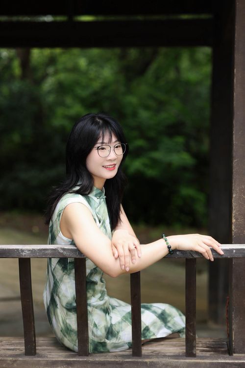 Free Happy young woman in a green cheongsam relaxing outdoors in Hefei, China. Stock Photo