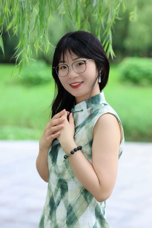 Free Elegant woman posing in a park in Hefei, Anhui wearing traditional attire and glasses. Stock Photo