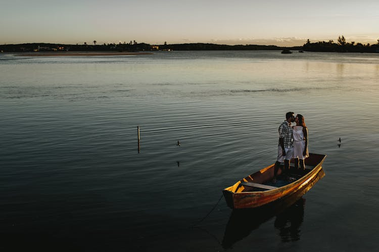 Anonymous Young Couple Kissing In Wooden Boat