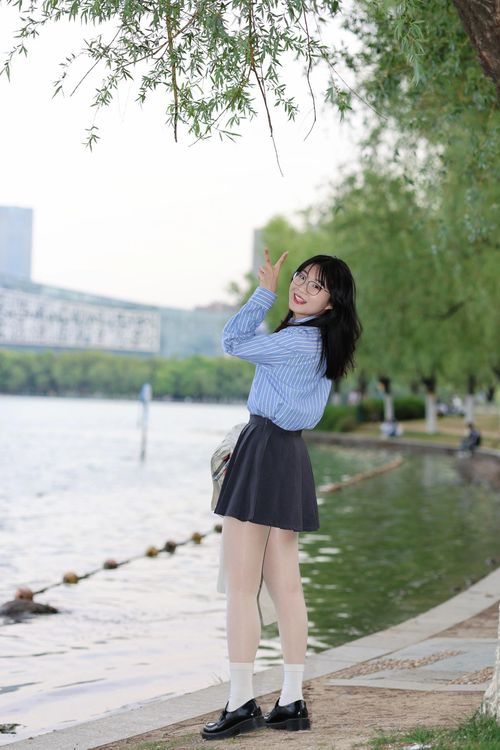 Free A cheerful young woman poses by a serene lakeside in Hefei, China, capturing a joyful outdoor moment. Stock Photo