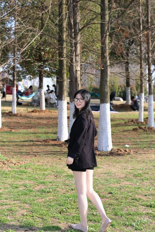 Free A young woman walking through a park in Hefei, Anhui, China on a sunny day. Stock Photo