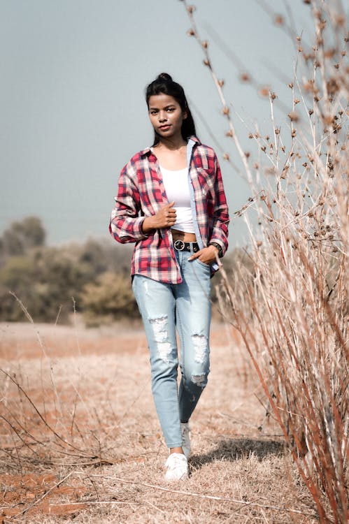 Free Female traveler walking along dry grass Stock Photo