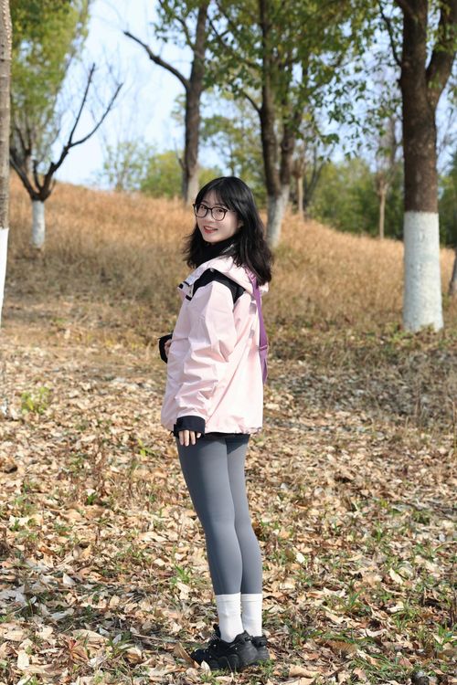 Free A young woman enjoying a stroll in a scenic park in Hefei, Anhui, surrounded by autumn foliage. Stock Photo