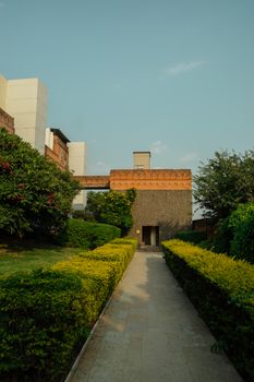 A modern architectural building with a beautiful garden pathway under a clear blue sky. - Fotografer Sidoarjo