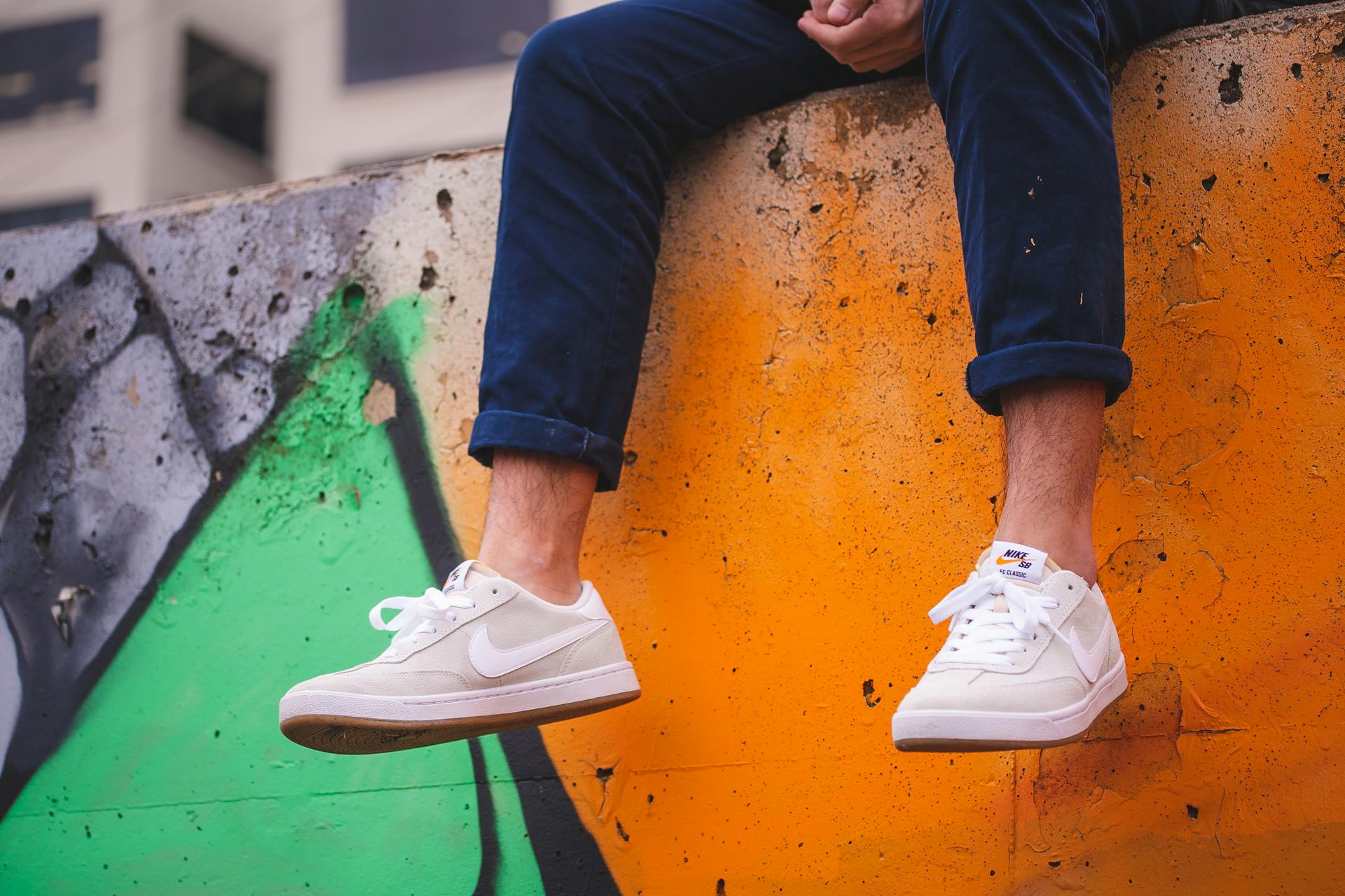 White sneakers against vibrant graffiti wall. Des Moines urban scene.