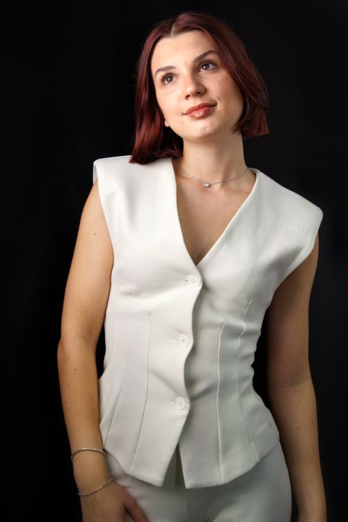 Free Stylish portrait of a woman in a tailored white vest. Ideal for fashion and lifestyle themes. Stock Photo