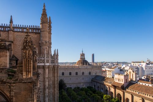 Free View of Seville Cathedral's Gothic architecture under clear blue skies. Stock Photo