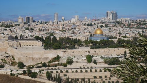 Free Panoramic view of Jerusalem featuring the iconic Dome of the Rock and city skyline under a clear blue sky. Stock Photo