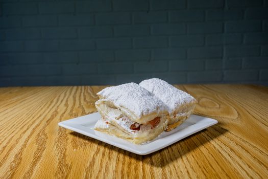 A delectable puff pastry dusted with powdered sugar, served on a plate.