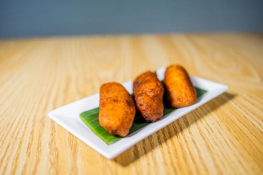 Freshly fried plantains served on a white plate, perfect for a savory snack.