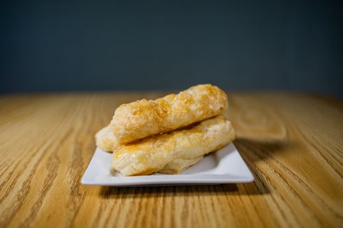 Free Golden, flaky pastry sticks arranged on a white plate, perfect for a gourmet meal. Stock Photo