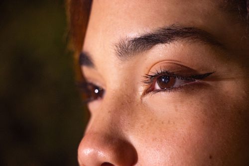 Free A detailed close-up of a woman's eyes with prominent eyeliner, captured in natural lighting. Stock Photo