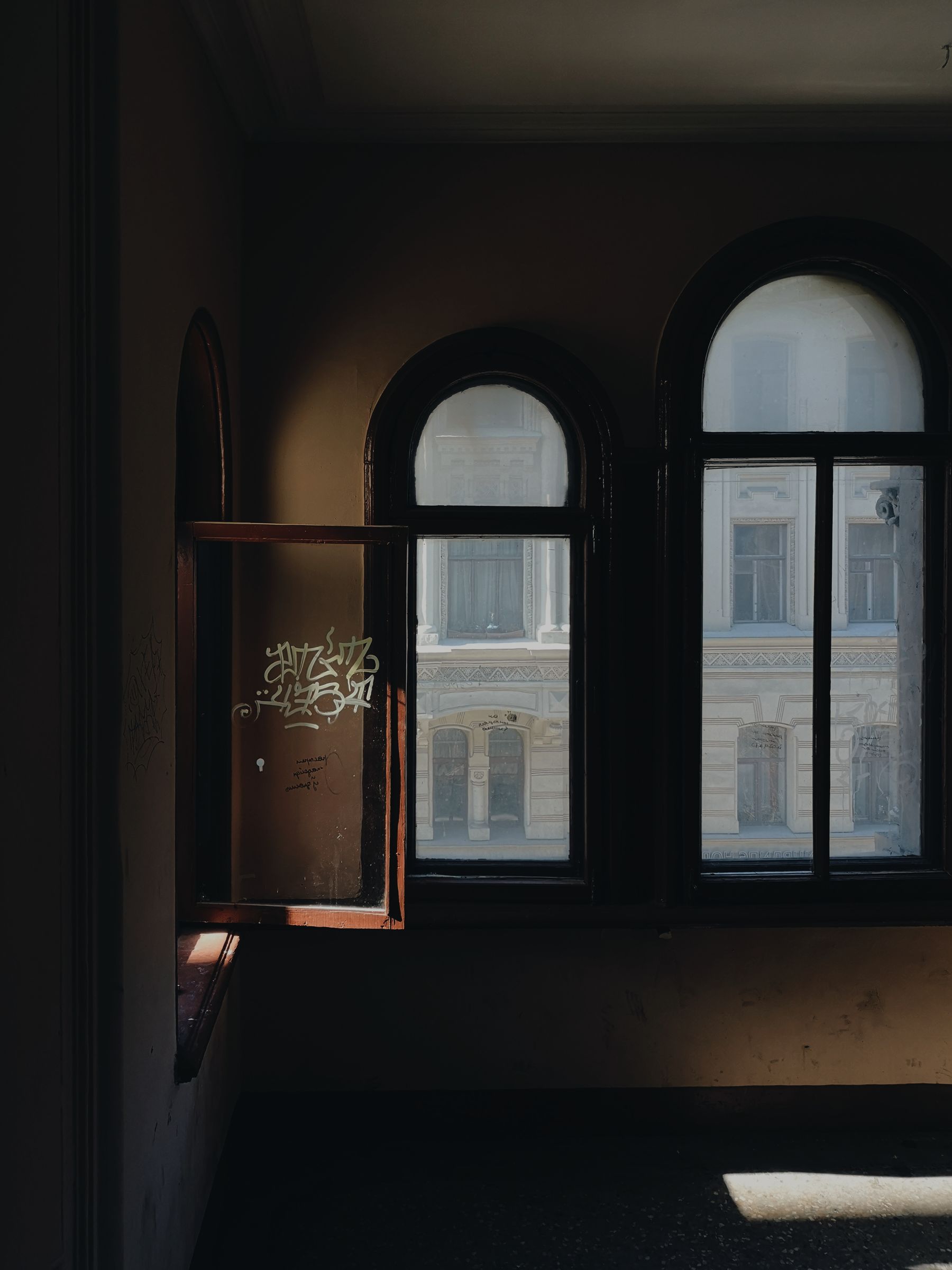Dark empty room with tall arched windows
