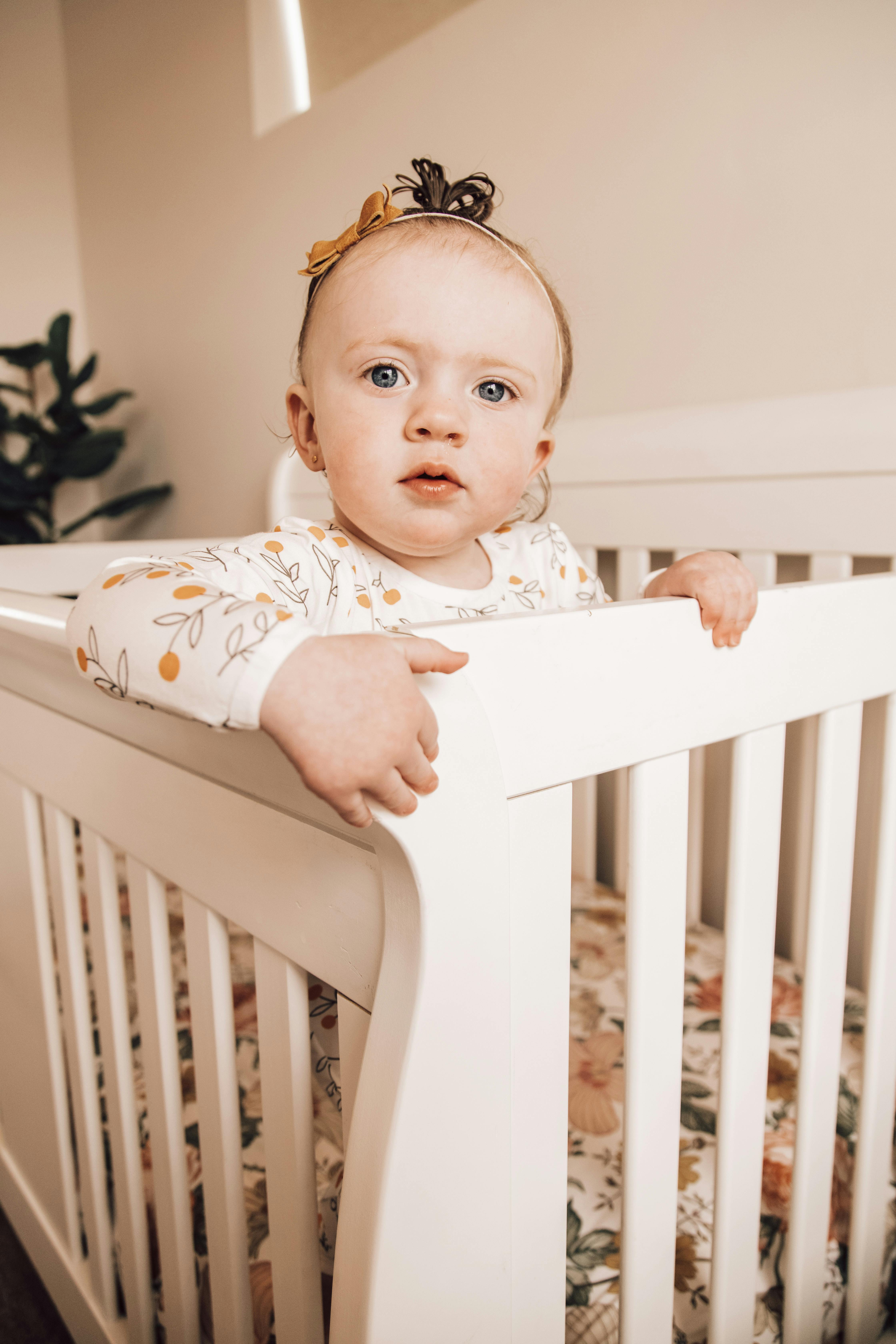 pensive little girl resting in crib