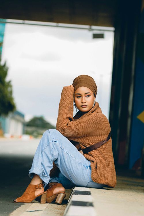 Free Young woman in Abuja poses stylishly in an urban street setting, wearing casual attire. Stock Photo