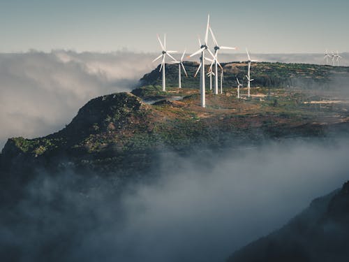 White Wind Turbines on Green Grass Covered Hill