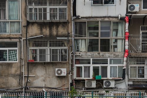 Free Close view of old apartment building facade with air conditioners and laundry hanging. Stock Photo