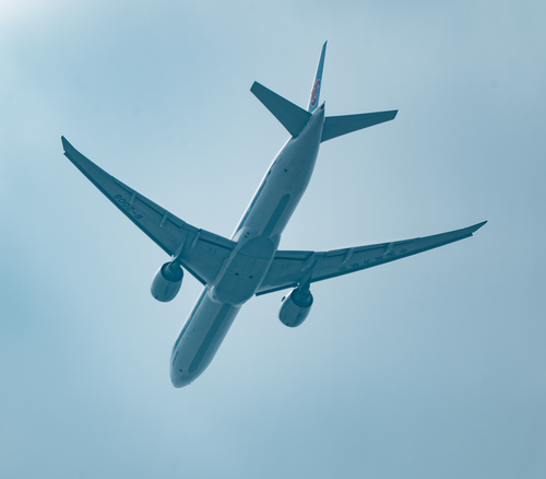 Free An airplane captured from below flying through a clear blue sky. Stock Photo