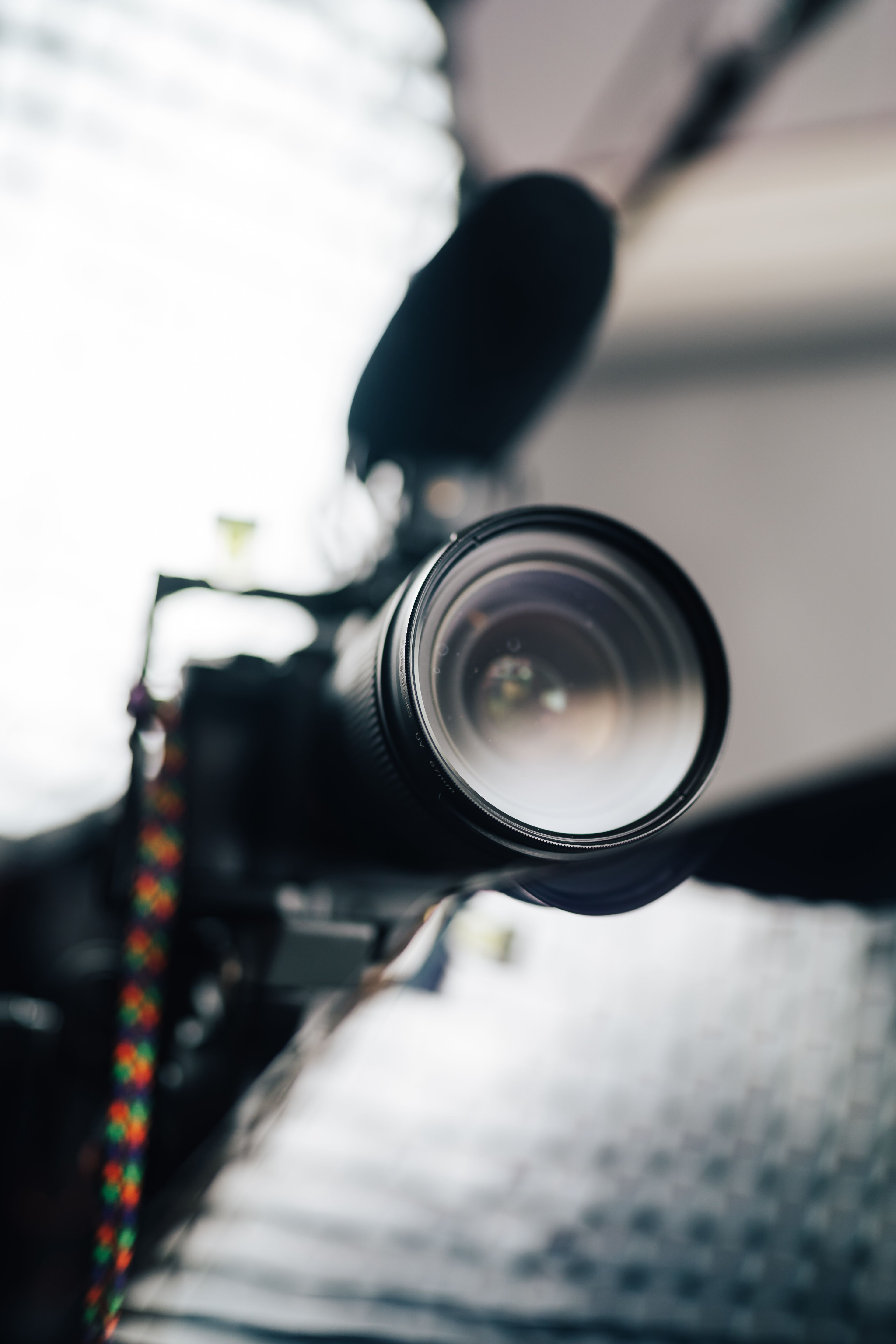 Close-up view of a professional camera lens with microphone, ideal for photography and videography enthusiasts.