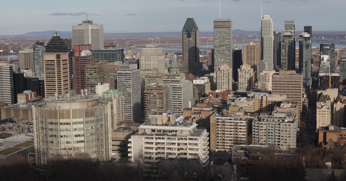 Panoramic view of Montreal's skyline with iconic skyscrapers under a clear sky.