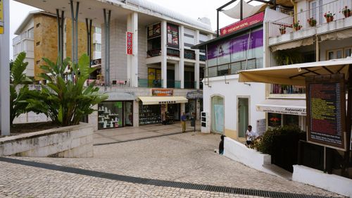 Free View of a commercial street with shops and modern architecture in Colares, Portugal. Stock Photo