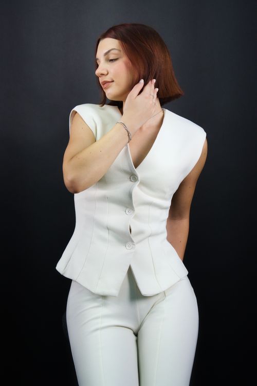 Free Elegant woman in modern white business suit posing against a dark background. Stock Photo