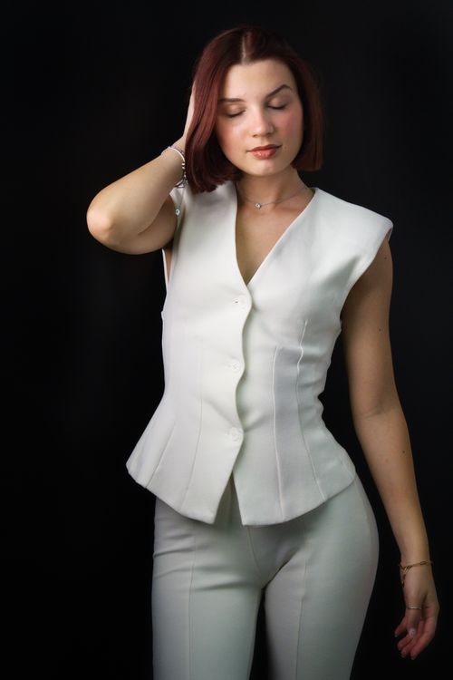 Free Fashion portrait of a woman in an elegant white suit on a dark background, exuding elegance and sophistication. Stock Photo