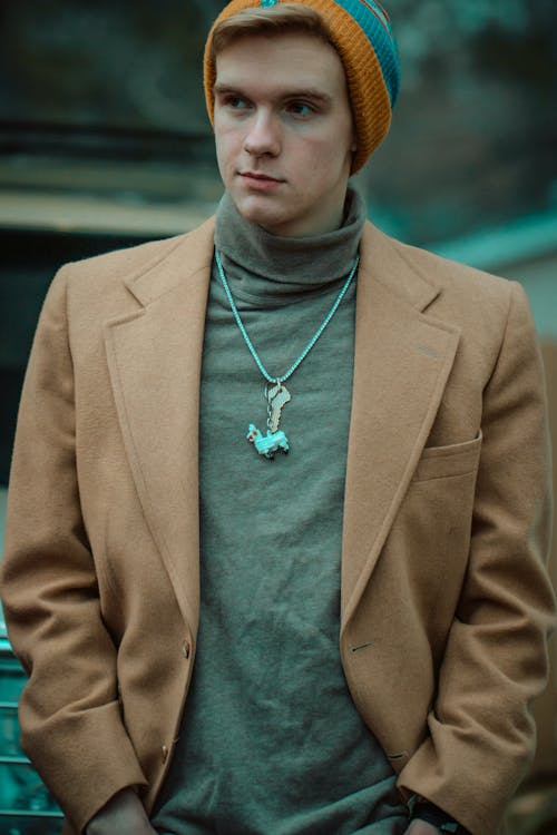 Man in Brown Coat Wearing Blue and Brown Beanie 