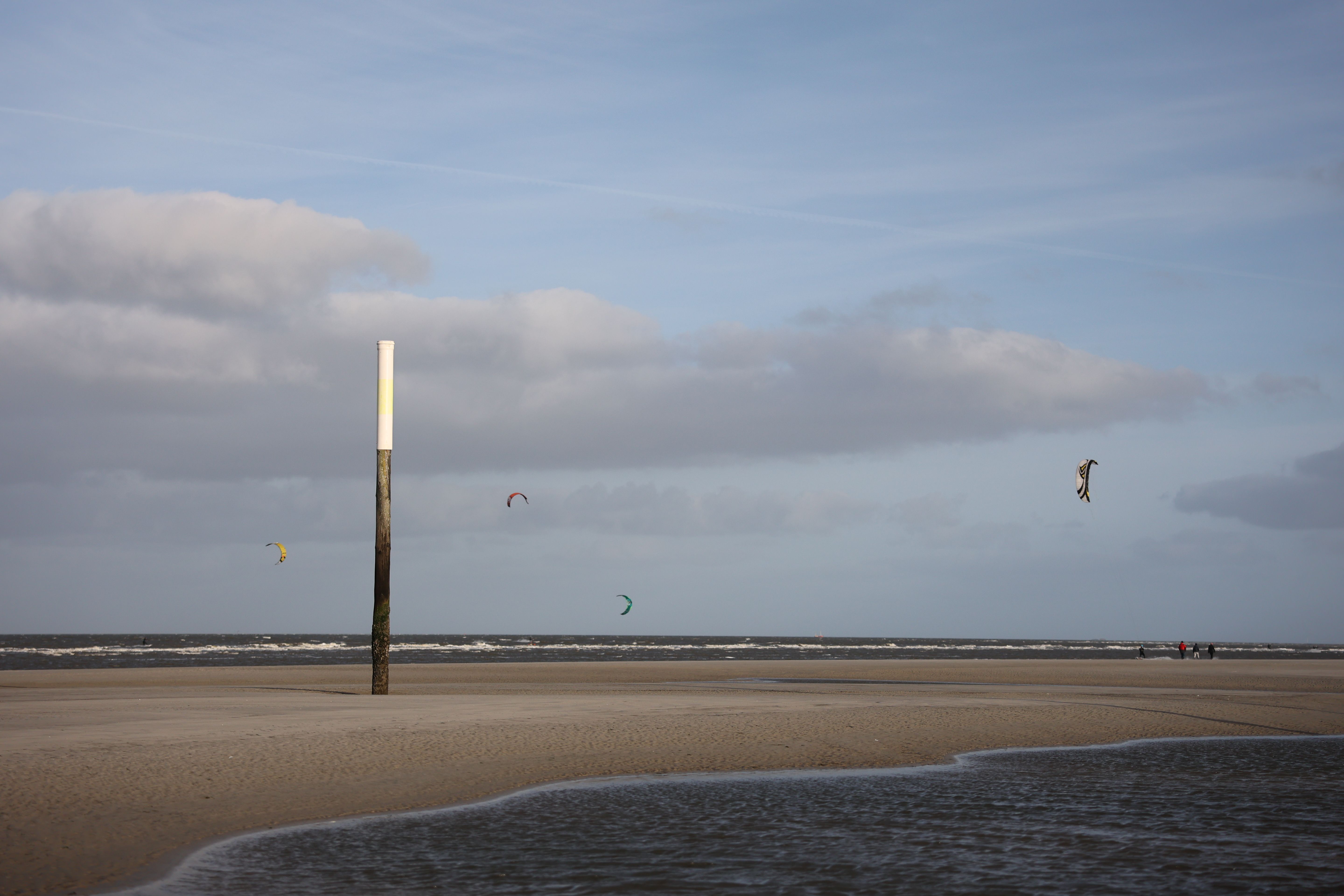 Capture of kitesurfers navigating the winds at Sankt Peter-Ording, Germany.